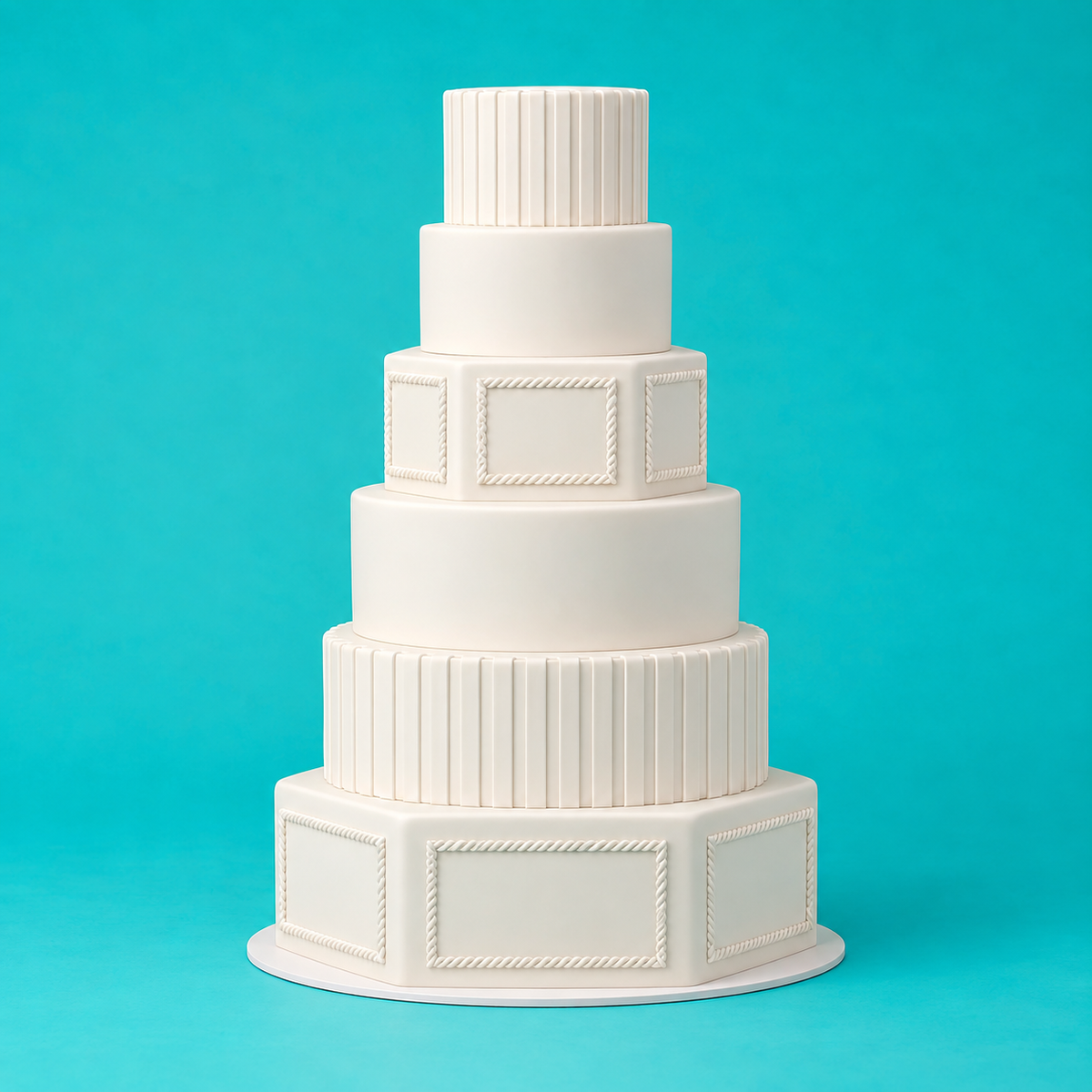 Elegant six-tier white wedding cake built on hexagon and round foam cake dummies