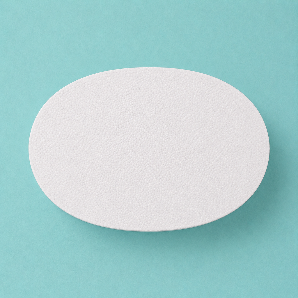 Oval foam cake dummy 10 by 7 inch, seen from above showing the true elliptical profile, smooth white finish