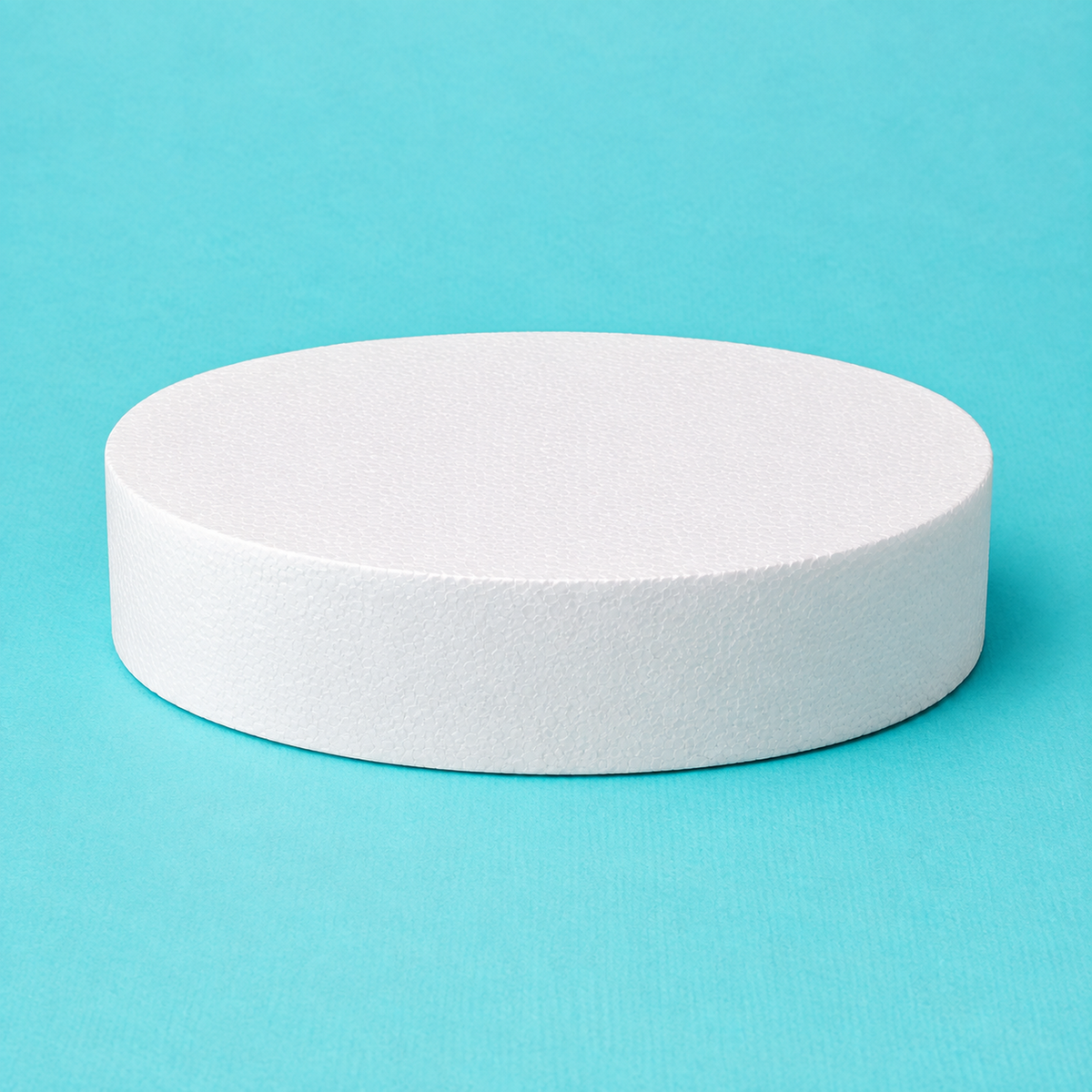 Oval foam cake dummy 12 by 9 inch, 3 inches tall, seen from the front showing the perpendicular side and crisp top rim