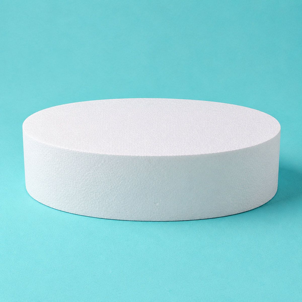 Oval foam cake dummy 14 by 10 inch base tier, 4 inches tall, seen from the front showing the perpendicular side and crisp top rim