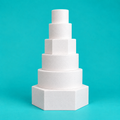 Six-tier hexagon and round foam cake dummy wedding tower, 14, 12, 10, 8, 6 and 4 inch tiers, white finish on turquoise background