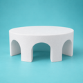 Round foam cake dummy with three evenly spaced arch cutouts through the tier, smooth white finish